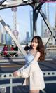 A woman in a blue dress standing on a bridge.