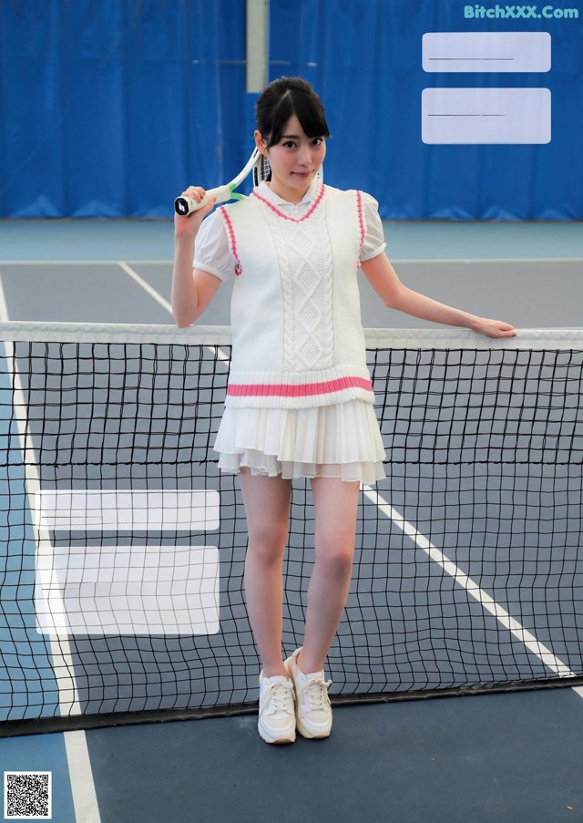 A woman holding a tennis racquet on a tennis court.