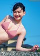 A woman in a red and white striped bikini posing for a picture.