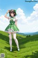 A girl in a green dress standing in a field.