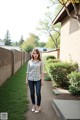 A woman standing in front of a brick building.