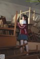 A woman in a school uniform standing in front of a pile of chairs.